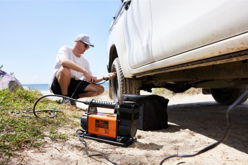 Young man inflating tyres with XTM compressor